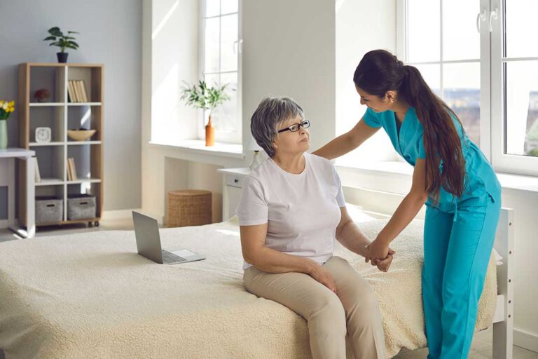 An adult daughter talking with her elderly mother in a cozy assisted living room.