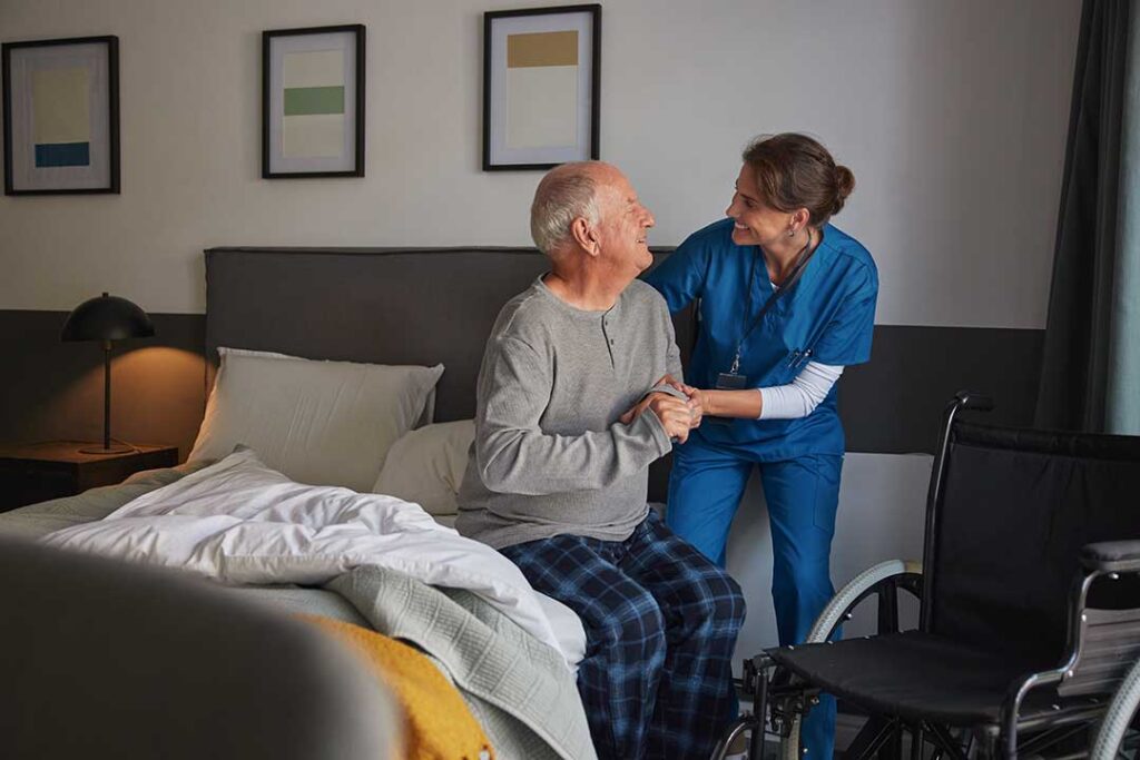 Older adults participating in a group exercise class, smiling and stretching together in a bright common room.